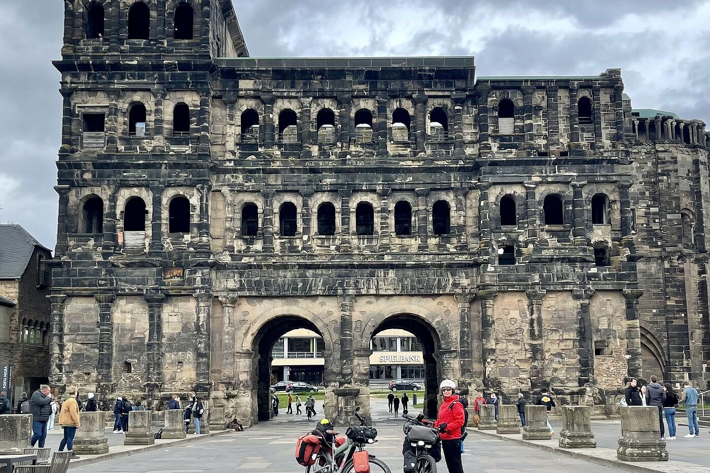 Zwei Fahrräder und eine Frau vor dem Porta Nigra in Trier