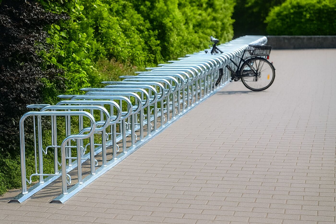 Eine Fahrradabstellanlage aus Stahl auf einem Parkplatz.